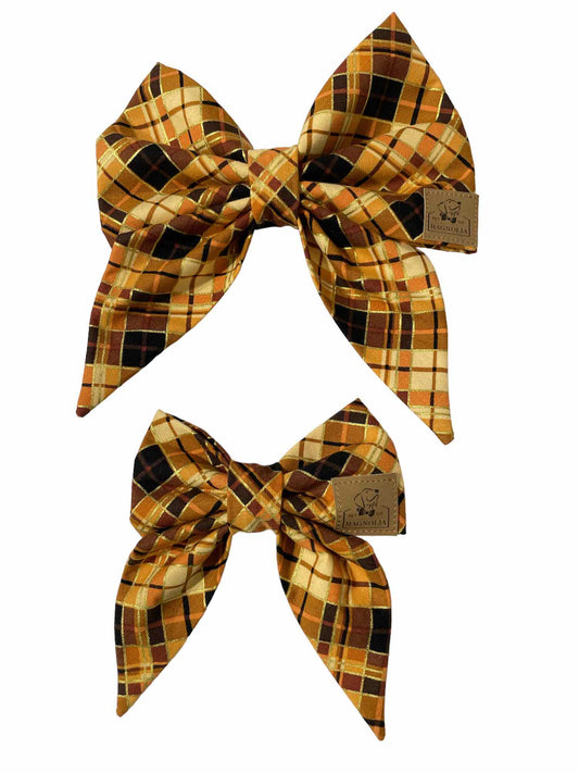 This dog bow has warm tones yellow, orange and black with a pop of shimmering gold.