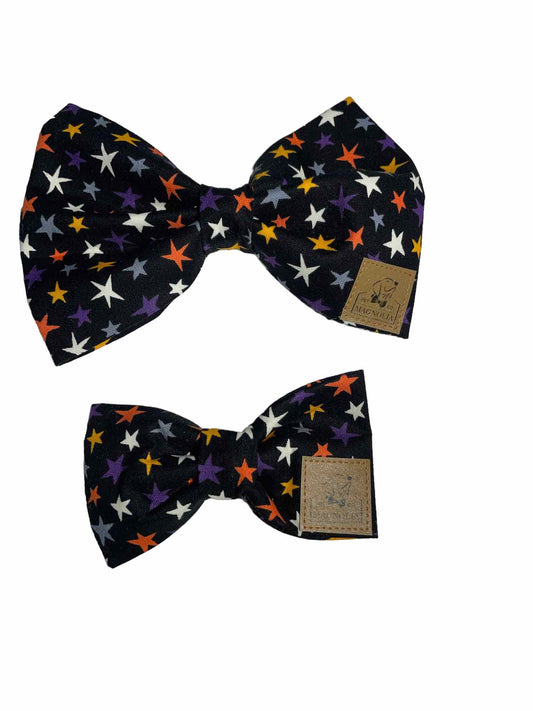 Featuring a sleek black background adorned with white, orange, yellow, and grey stars, this bow isn't just out-of-this-world cute—it glows in the dark!