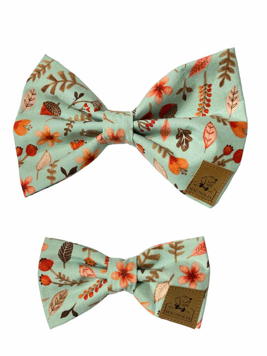 Made from light blue fabric and adorned with soft, muted orange acorns, leaves, and flowers