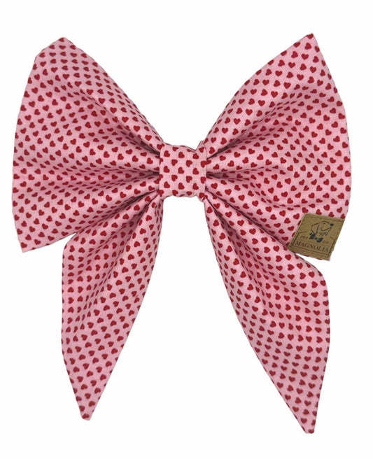 Dog Bow featuring soft pink fabric sprinkled with tiny red hearts creates an irresistibly sweet and stylish look.