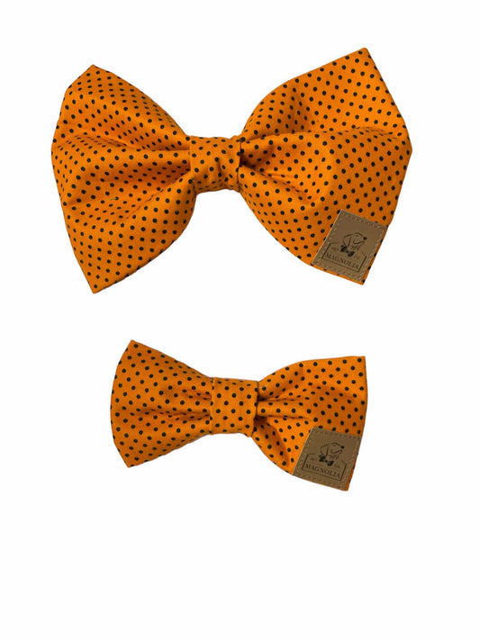This charming accessory features a vibrant orange fabric adorned with petite black polka dots, adding a fun and playful touch to your furry friend's wardrobe.