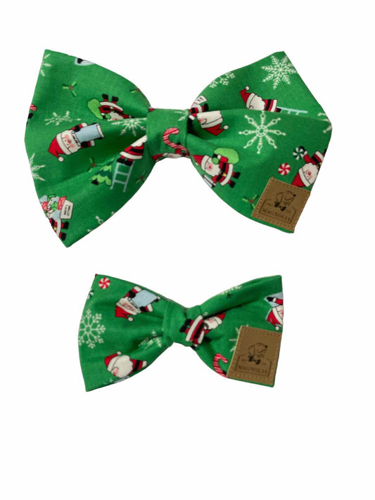 This festive accessory features a vibrant bright green fabric adorned with cheerful Santa Claus illustrations