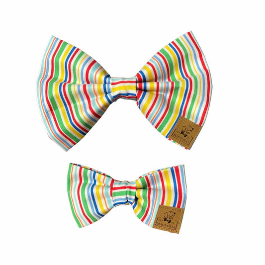 Featuring vibrant stripes of yellow, blue, and green, this bow radiates the warmth and joy of a summer celebration. Whether your pup is attending a birthday bash, a sunny picnic, or simply spreading happiness wherever they go, this bow tie is sure to make them the life of the party.  Crafted with attention to detail and comfort, our Bright Stripe Dog Bow ensures a secure and comfortable fit for your canine companion.