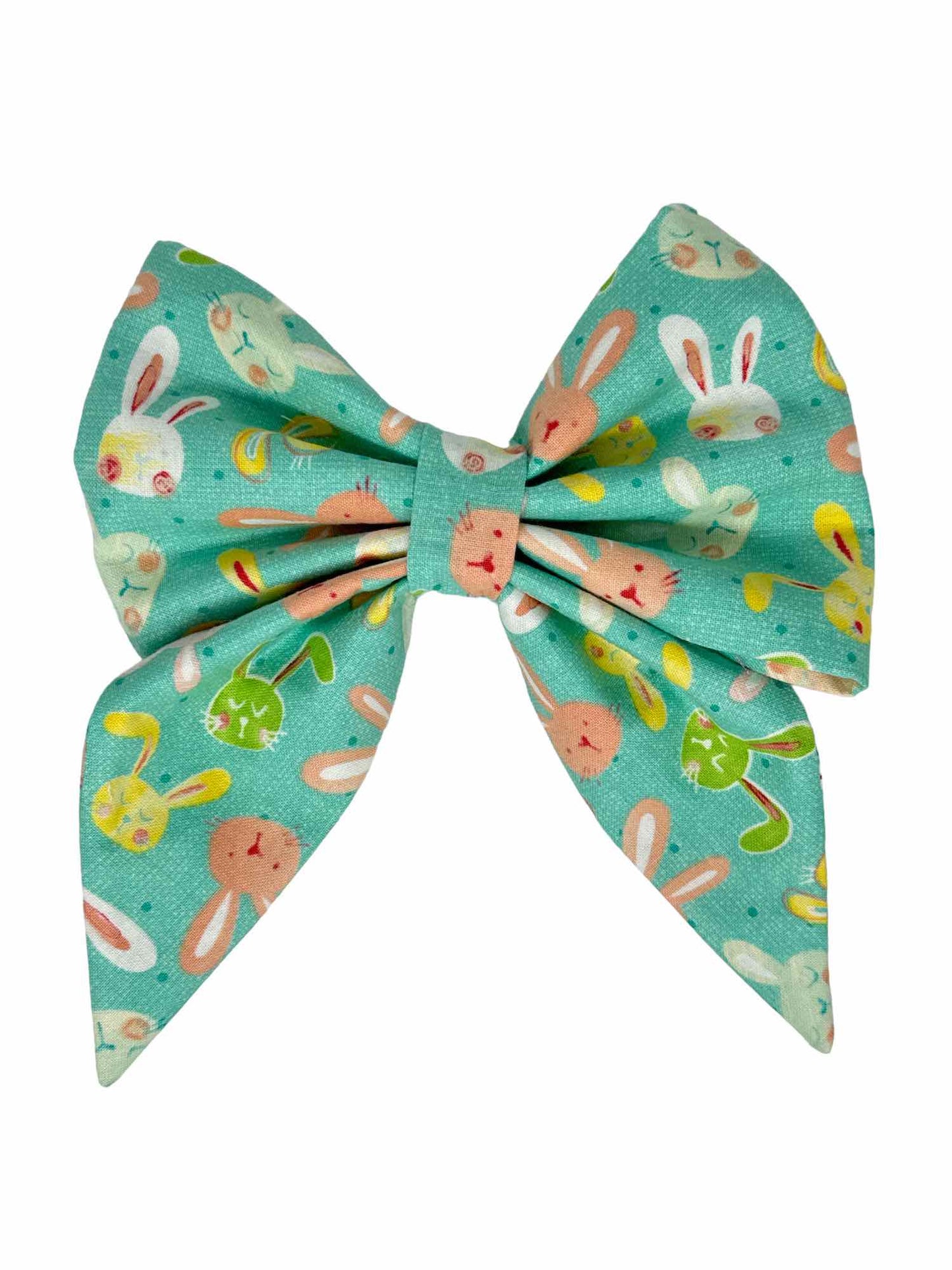 Hop into Spring with our delightful Bunny Hop Dog Bow – the perfect accessory to add a touch of whimsy and cheer to your pet's ensemble! Featuring a charming print of cute illustrated bunny faces in tones of pink, yellow, green, and white on a soft pastel aqua background, this bow captures the essence of springtime joy.