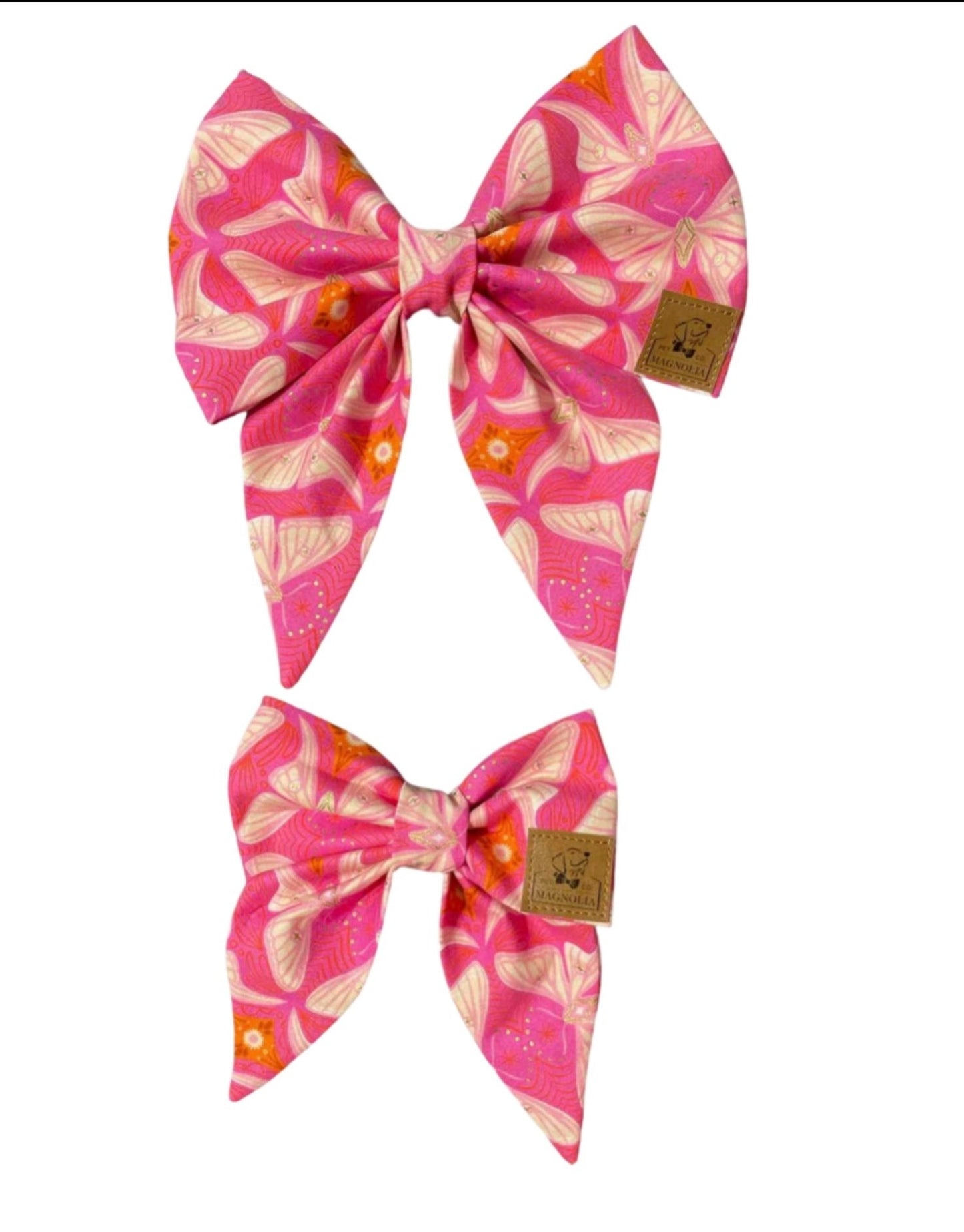Let your dog flutter into the spotlight with this enchanting bow — our Majestic Pink Butterfly Dog Bow, crafted to add an ethereal flair to their ensemble. Carefully designed with attention to detail, this enchanting bow features butterflies in creamy hues delicately poised against a vibrant pink backdrop, with a subtle hint of orange to enhance its flair.