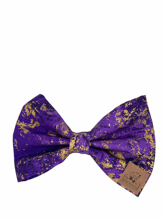 This luxurious accessory is crafted from deep, rich purple fabric, accented with enchanting splashes of gold glitter.