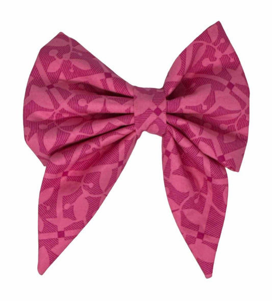Dog bow featuring bright pink fabric adorned with enchanting dark pink floral designs.