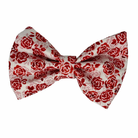 Dog bow tie featuring dazzling red roses with a hint of sparkle and delicate soft pink roses, all beautifully set against a cream white background.