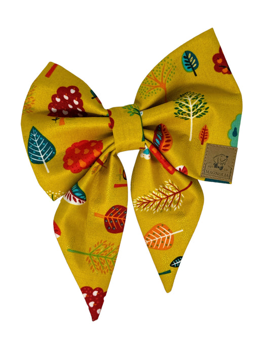 The beauty of a Tuscan sky is portrayed in this dog bowtie. The bowtie has a golden fabric with deeps reds, vibrant blues and green trees and leaves with small hints of glitter.