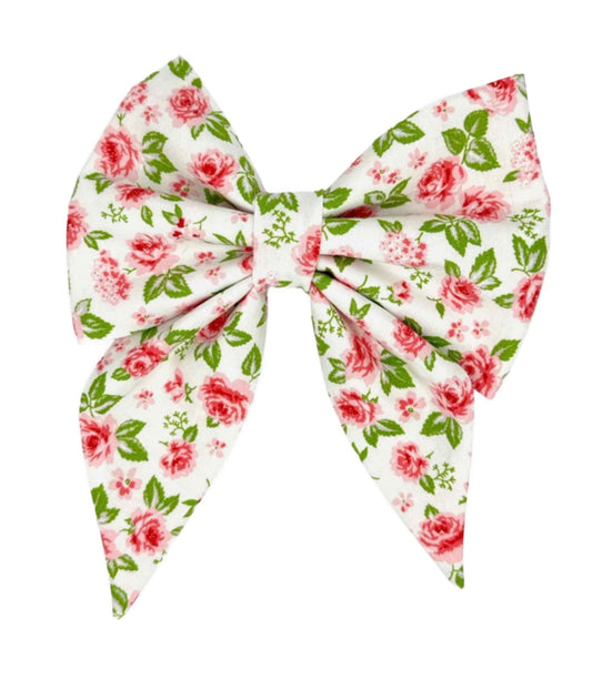 Transform your furry friend into a style icon with our Vintage Rose on White Bow. This beautifully crafted accessory features a pristine white fabric adorned with delicate pink roses, subtly accented with hints of green leaves.