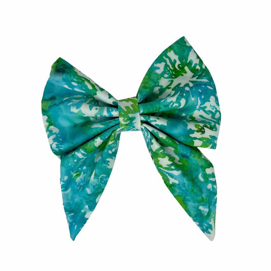 This striking accessory features a crisp white fabric background adorned with artistic splashes of blues and greens, creating a playful and eye-catching design.