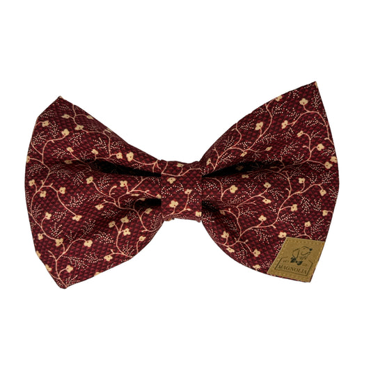 This sophisticated accessory features a rich maroon fabric adorned with delicate off-white floral vine patterns that weave gracefully throughout the fabric