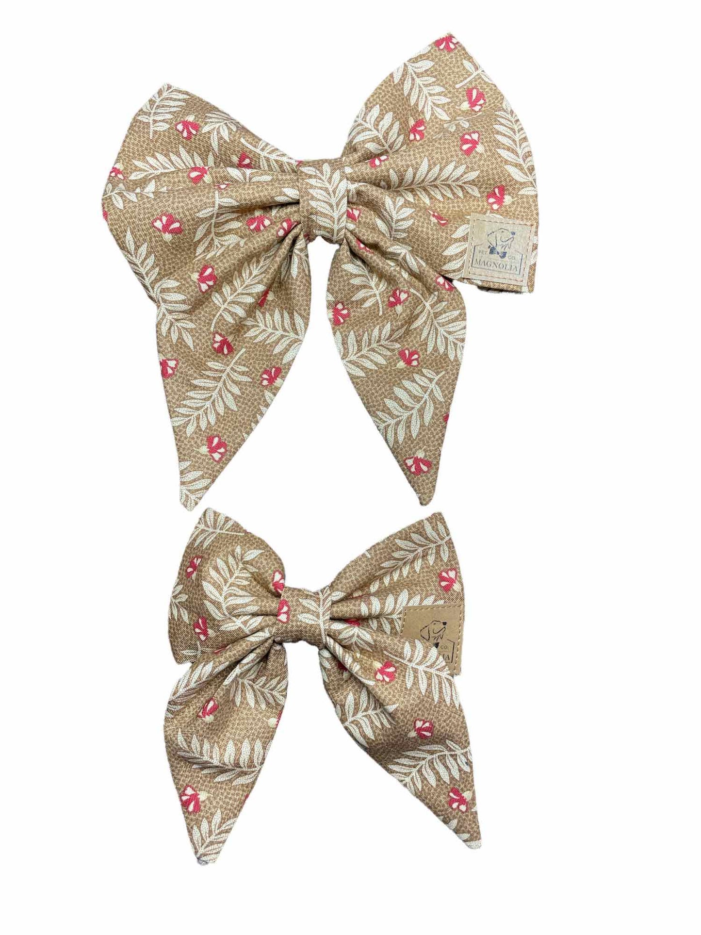mocha-colored fabric adorned with delicate white fronds and vibrant red rosy flowers
