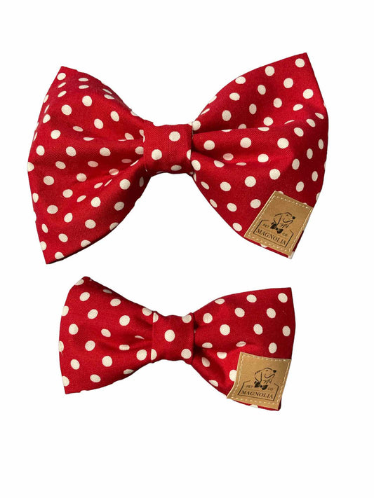 Crafted from vibrant red fabric adorned with playful white polka dots, this delightful bow is the perfect blend of whimsy and elegance.