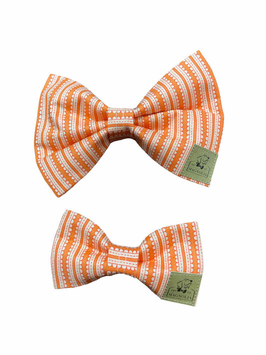 This delightful bow tie features an eye-catching pattern of white and orange stripes, perfect for adding a pop of color to any occasion