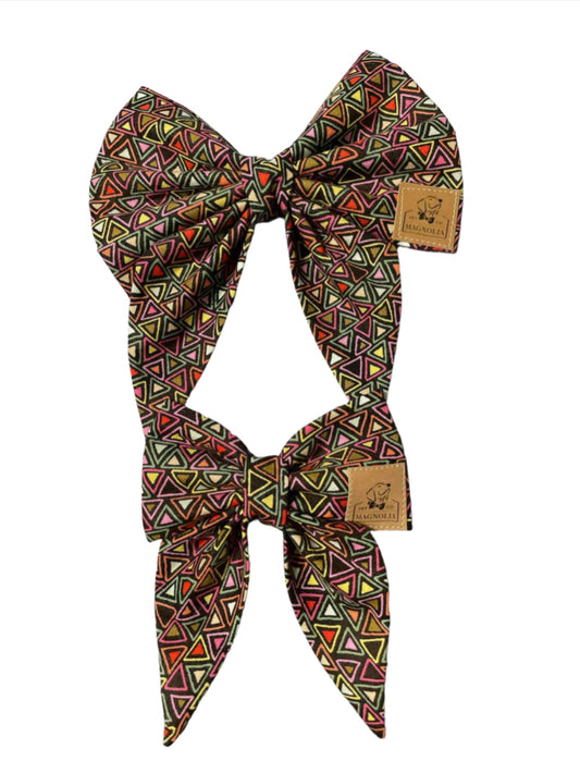 Add a pop of color and a touch of modern flair to your dog's look with our Triangle Maze Dog Bow on a black fabric background. This eye-catching accessory combines vibrant hues with sleek design, making it the perfect choice for style-conscious pet owners