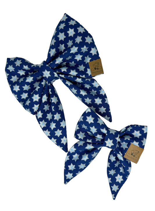 Dog bow featuring a dark blue background adorned with a glittery Star of David