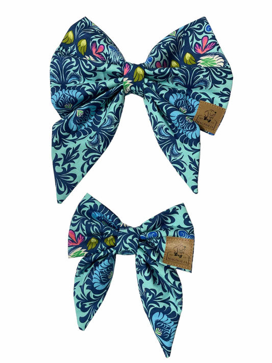 This stunning accessory features a bright blue fabric background adorned with a medium blue paisley pattern accented with vibrant touches of yellow and pink