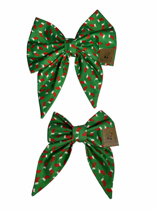 This delightful accessory features a charming green background adorned with petite red Christmas stockings, each topped with a classic white trim.
