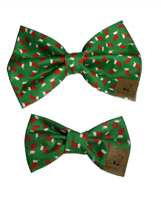 This delightful accessory features a charming green background adorned with petite red Christmas stockings, each topped with a classic white trim.