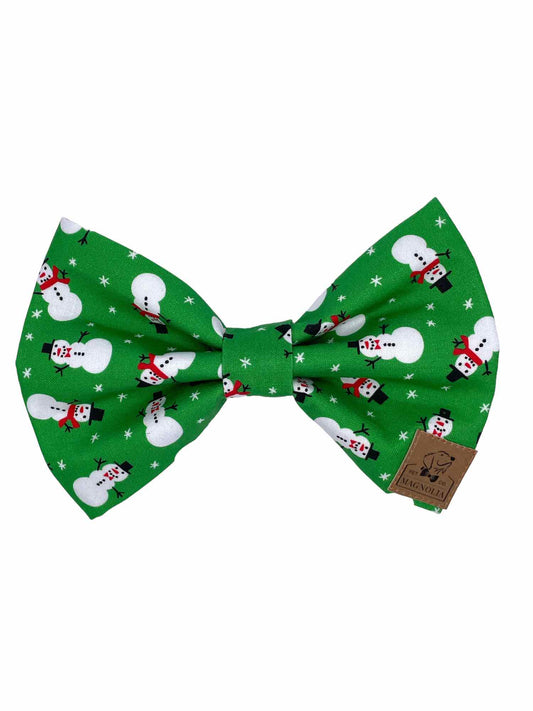 his festive accessory features a bright green fabric adorned with cheerful snowmen, each wearing a classic red scarf and a black hat