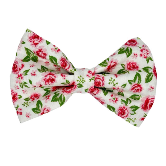This beautifully crafted accessory features a pristine white fabric adorned with delicate pink roses, subtly accented with hints of green leaves