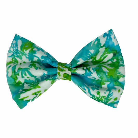 This striking accessory features a crisp white fabric background adorned with artistic splashes of blues and greens, creating a playful and eye-catching design.