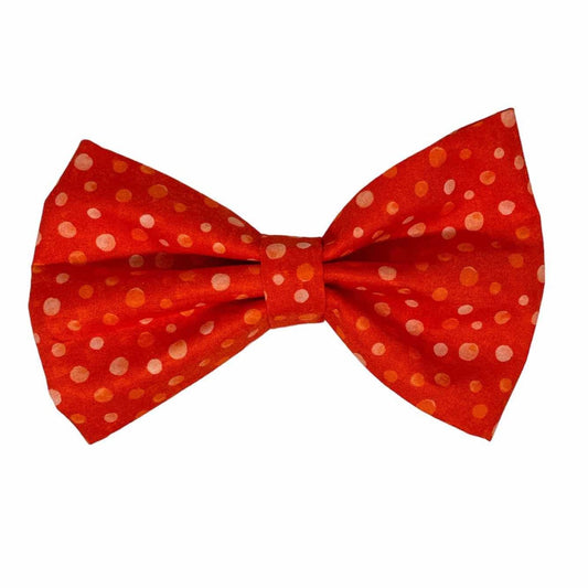 The bow is adorned with playful polka dots in shades of white, light orange, and burnt orange, creating a fun and eye-catching pattern that is sure to turn heads at the park or on your daily walks