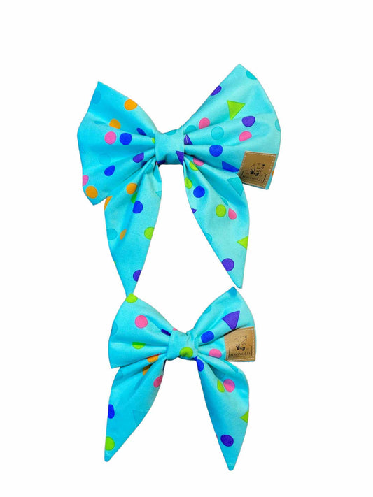 Time to celebrate! This dog bow features blue, pink, lime green and aqua confetti dots and triangles on an aqua background. Handmade in the USA