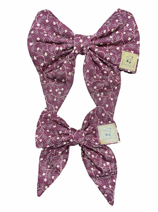 As you and your canine companion embark on leisurely walks through the park, surrounded by the crisp air and vibrant foliage of fall, this charming bow becomes the epitome of seasonal style. It's soft burgundy fabric, adorned with intricate cream vine patterns, captures the essence of autumn, making your furry friend a vision of elegance amidst nature's splendor.
