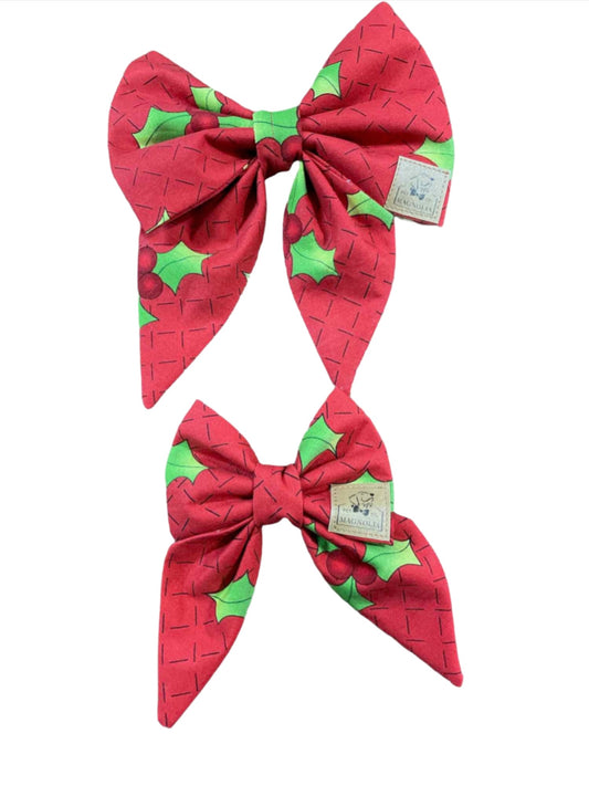 Featuring a vibrant red fabric adorned with cheerful green holly leaves, this delightful accessory is perfect for adding a touch of festive charm to your dog's look
