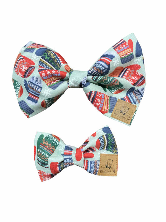 This adorable accessory features a soft light blue fabric, beautifully adorned with a delightful pattern of vintage mittens in shades of blue, red, and green